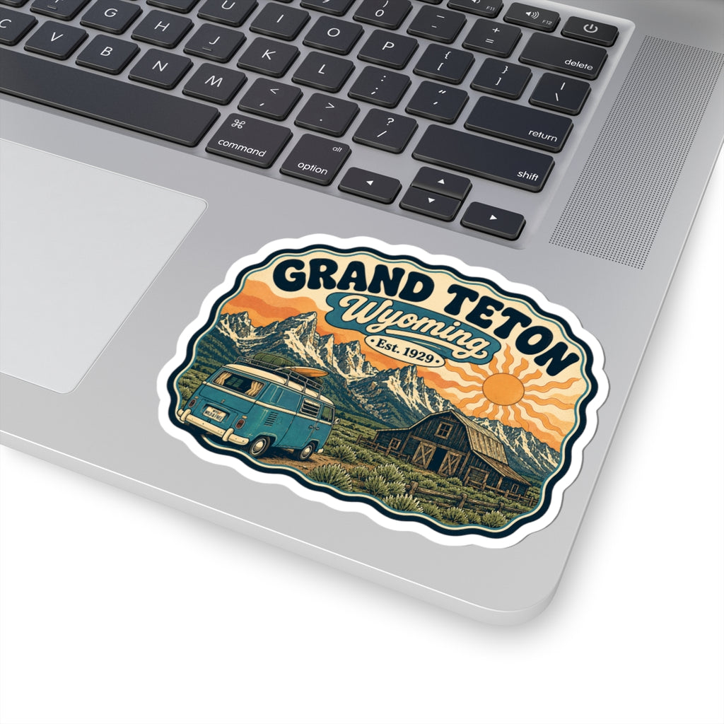 Grand Teton Wyoming sticker featuring teal camper van, barn, mountains, and orange sunset circle