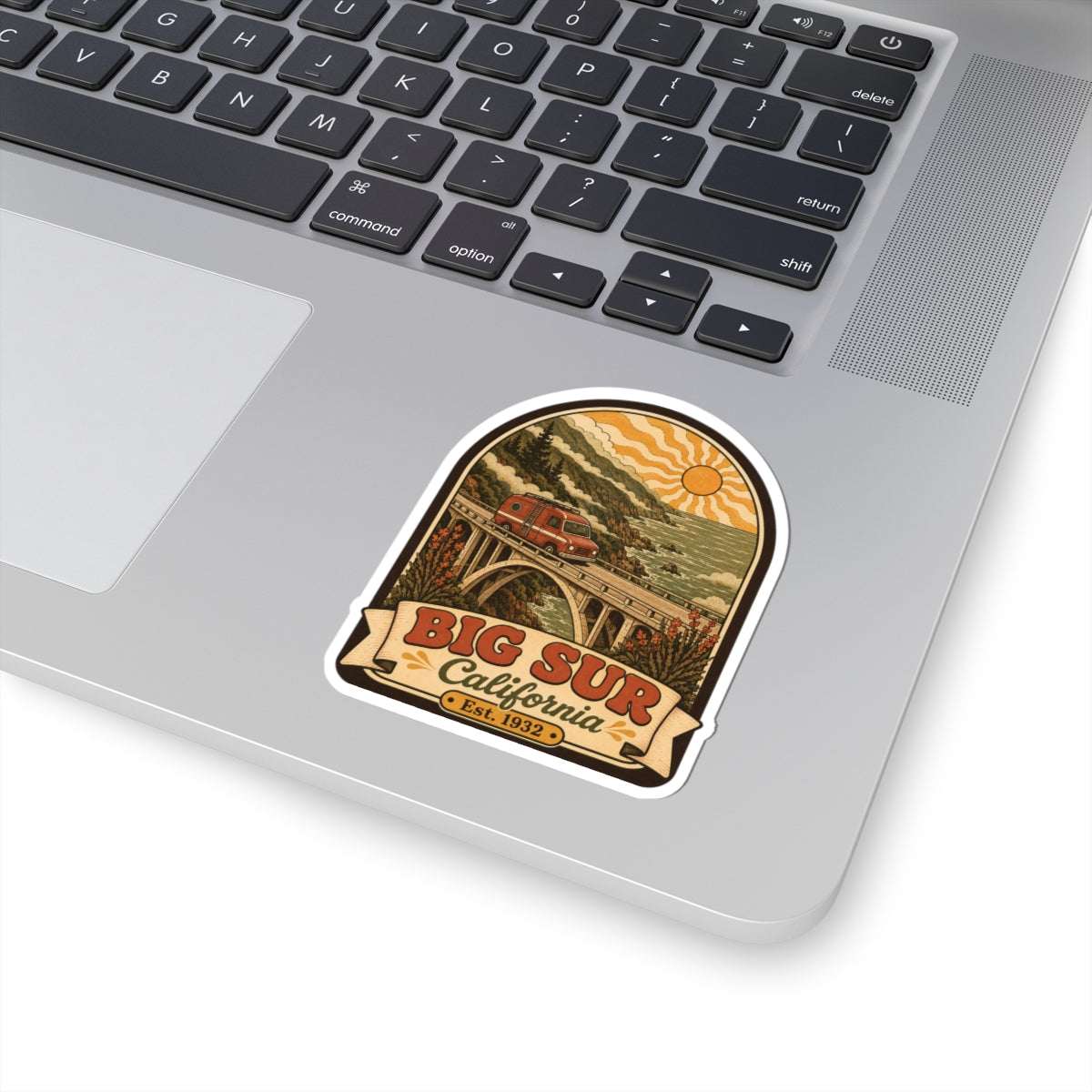 Big Sur camper van sticker on a laptop keyboard with retro bridge and sun