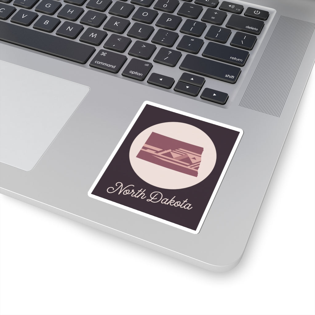 North Dakota square sticker with dark purple field, pale circle, maroon state silhouette icon