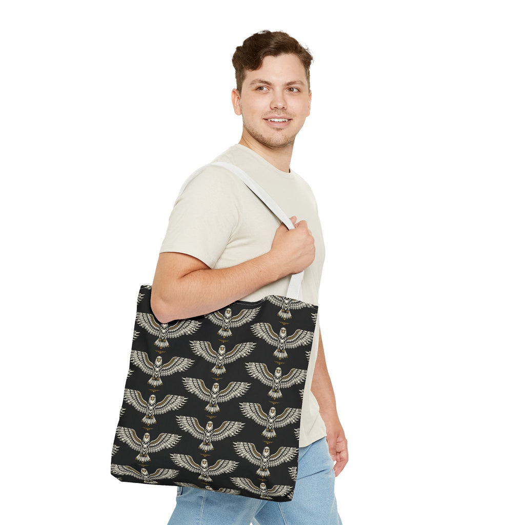 Scarab motif tote bag carried on shoulder, black panel with repeating gold winged designs