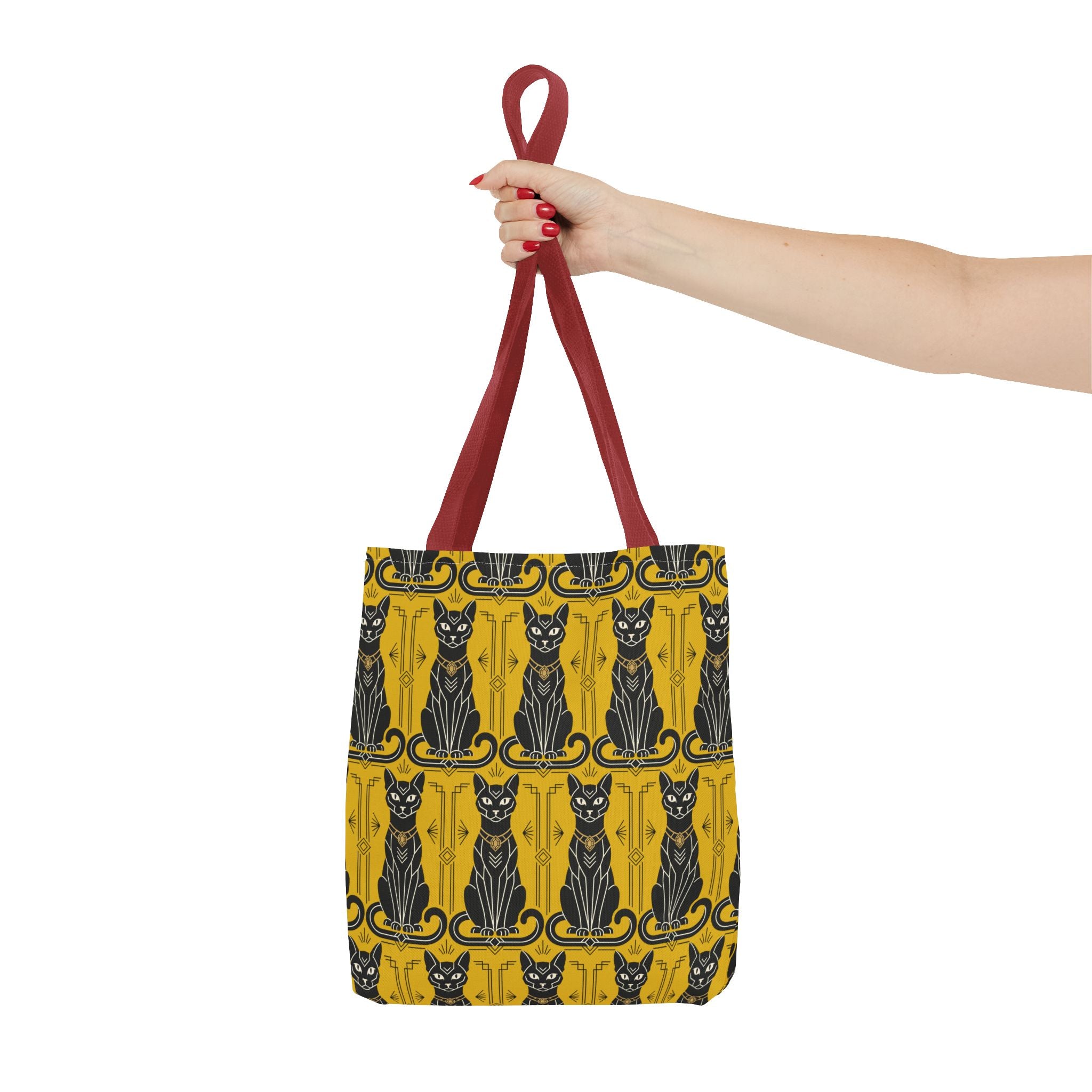 Yellow tote bag with black Art Nouveau cat pattern held by red top handles