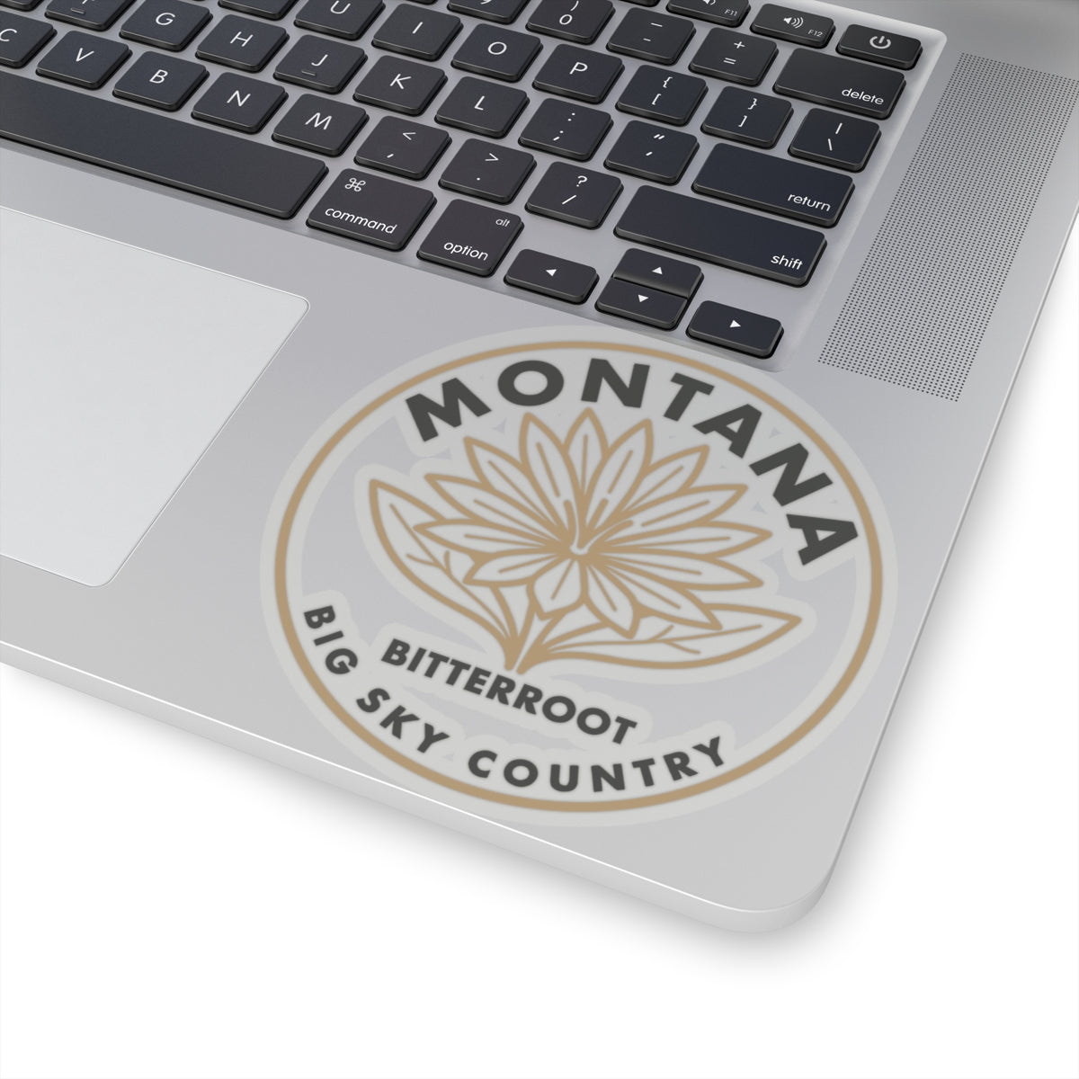Montana bitterroot sticker on laptop lid, beige flower graphic inside circular badge
