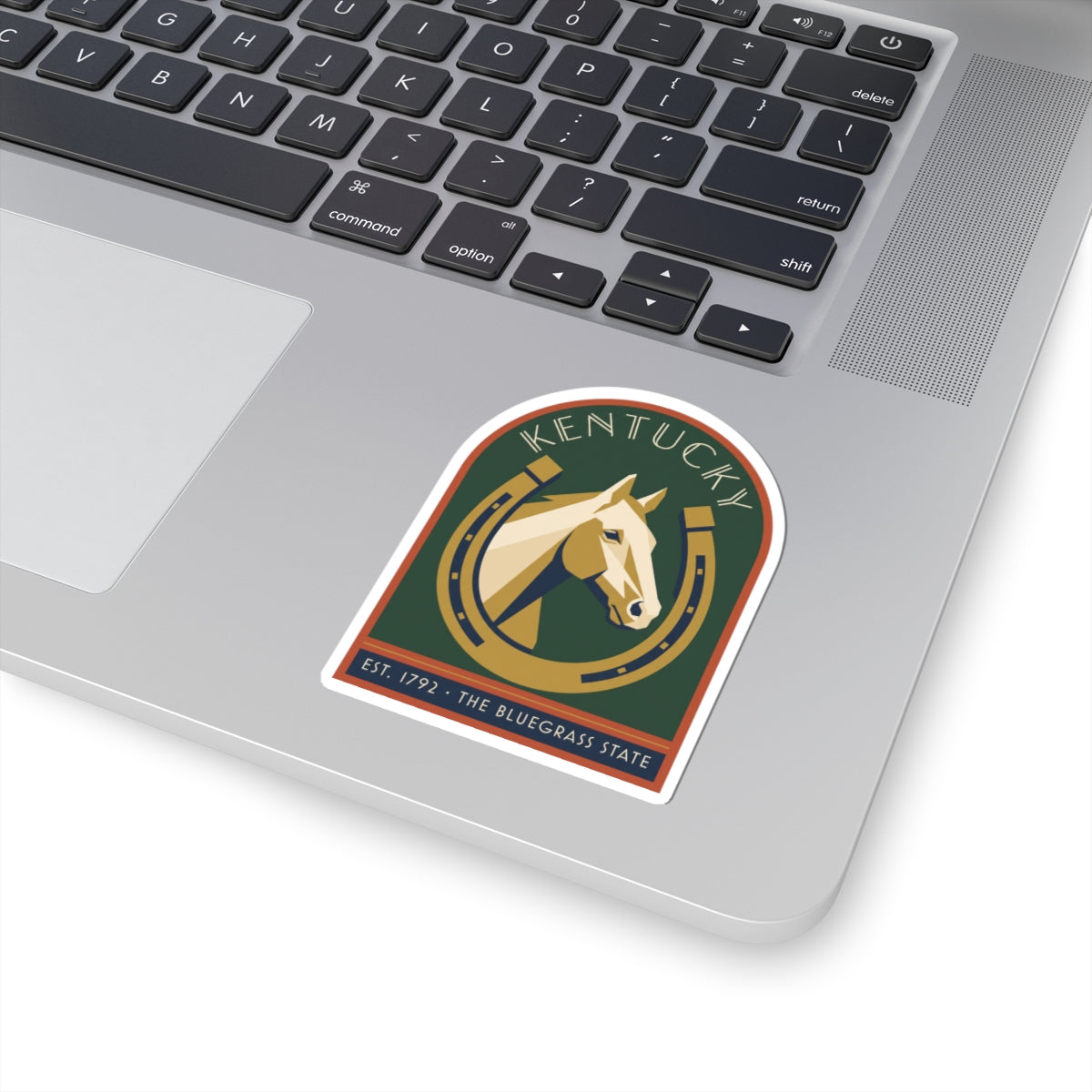 Kentucky horse sticker on white laptop surface, green circular seal “EST. 1792”