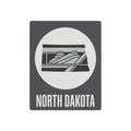 Dark gray North Dakota metal wall sign with white circle, landscape stripes, “NORTH DAKOTA” text