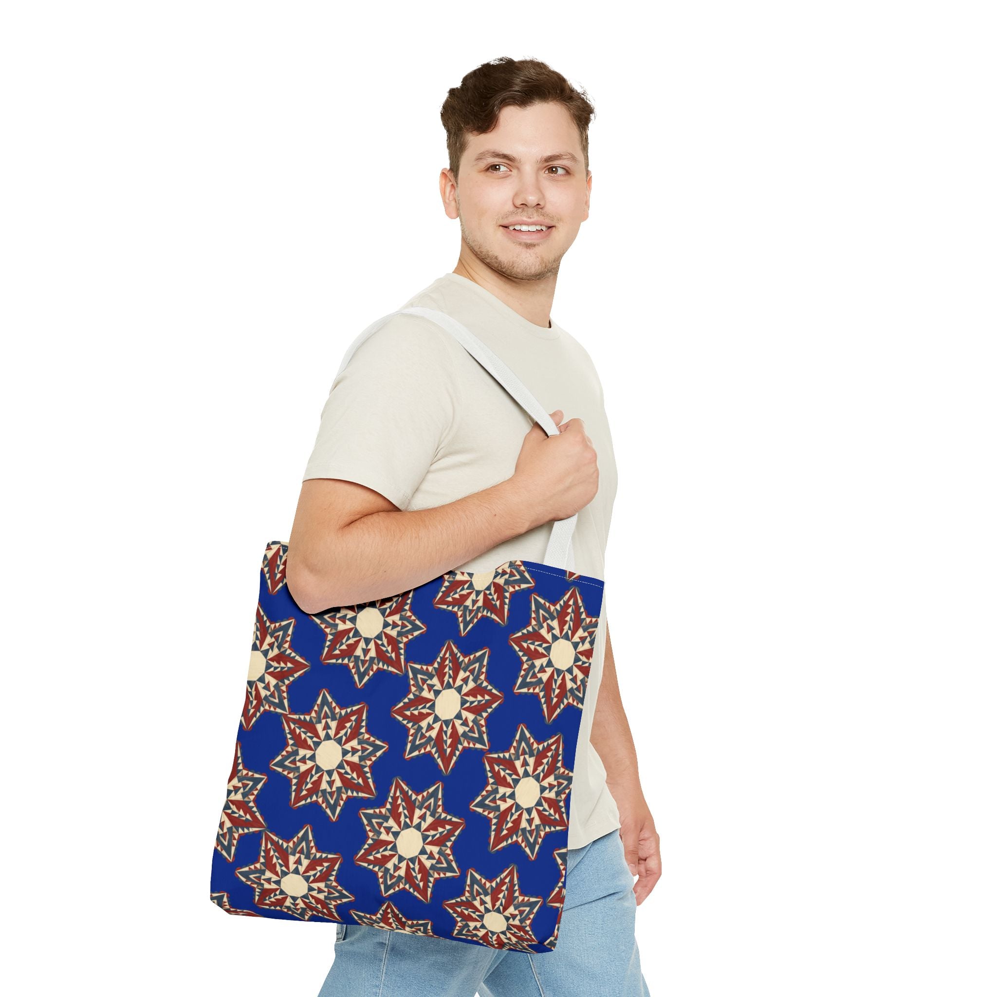 Blue canvas tote bag with cream and red starburst floral pattern, light handle straps