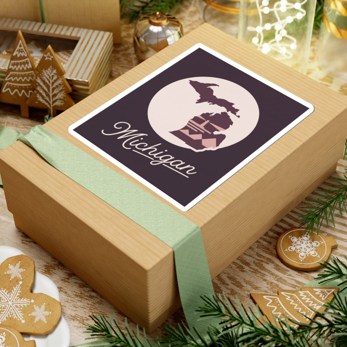 Michigan kiss-cut decal on a wrapped present: purple silhouette, lighthouse, and “Michigan” script in cream circle.