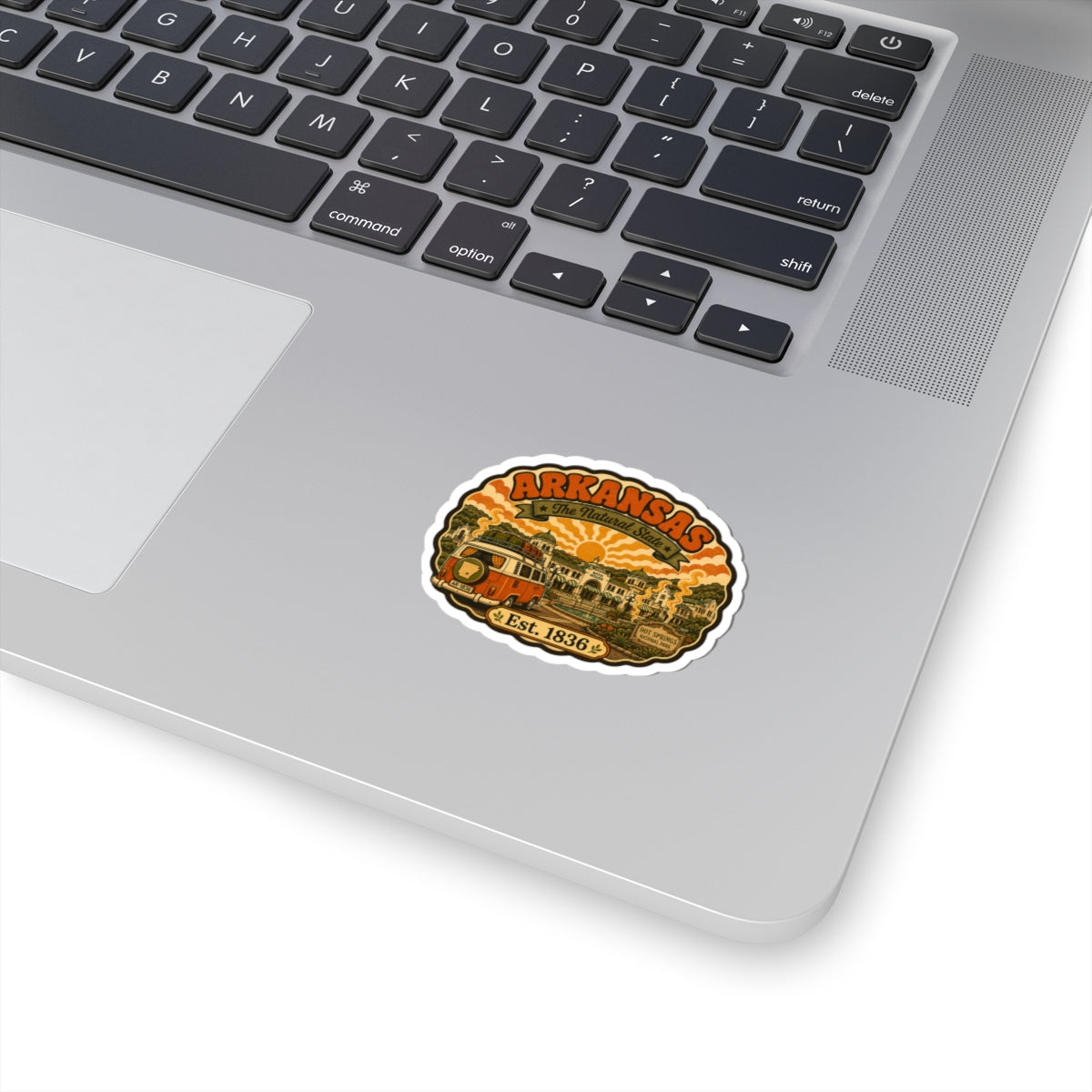 Arkansas retro camper van sticker with gold and orange graphic on white laptop