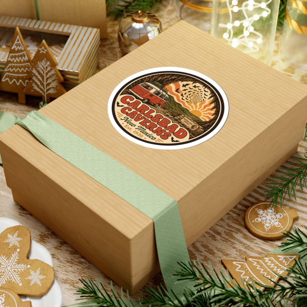 Round Carlsbad Caverns sticker on a gift box top, with orange camper van and desert cave design