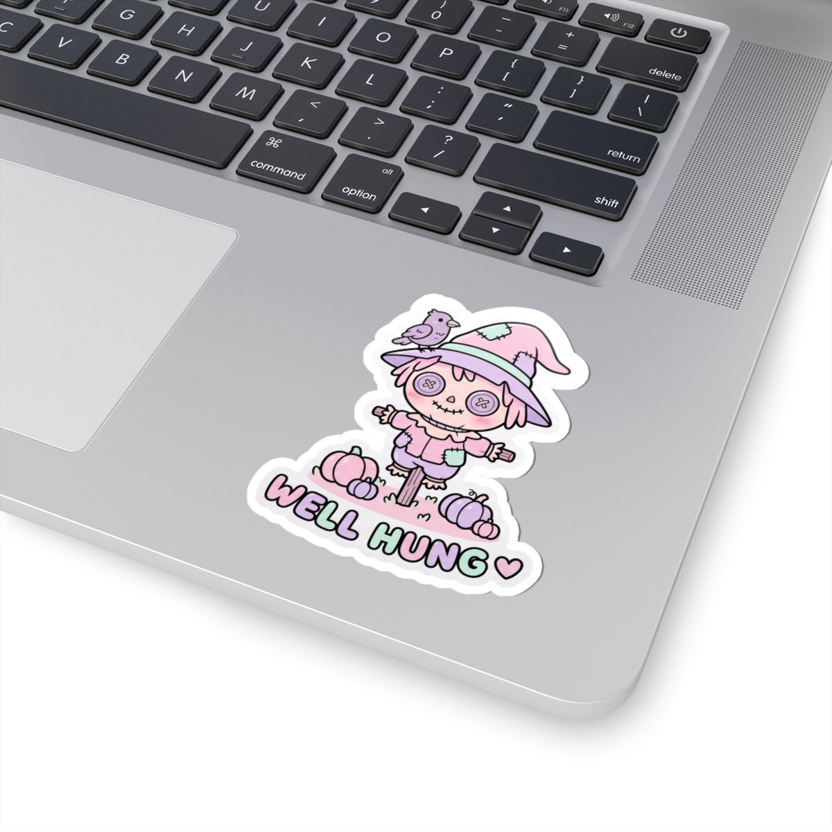 Cute pastel scarecrow bunny sticker with “WELL HUNG” text and pumpkins beneath
