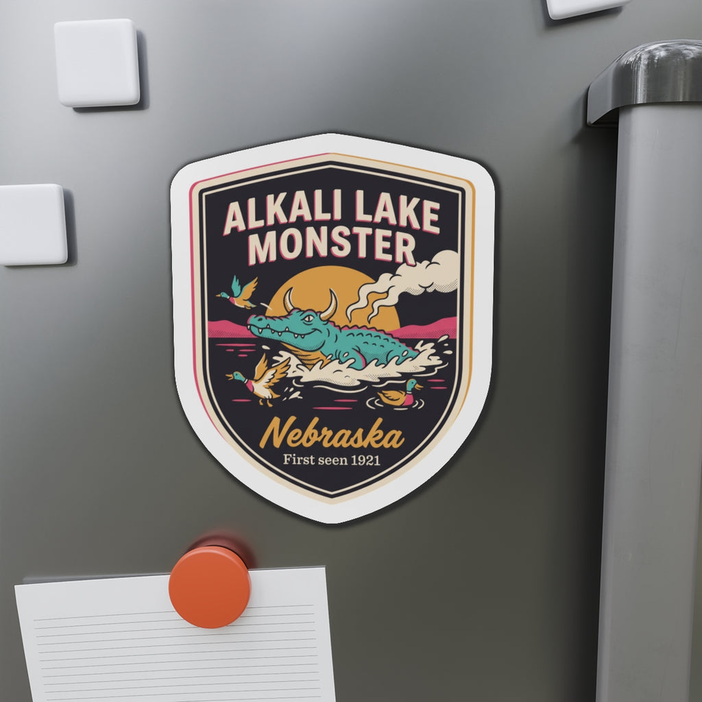 Shield die-cut magnet showing Alkali Lake Monster in orange-brown with Nebraska badge