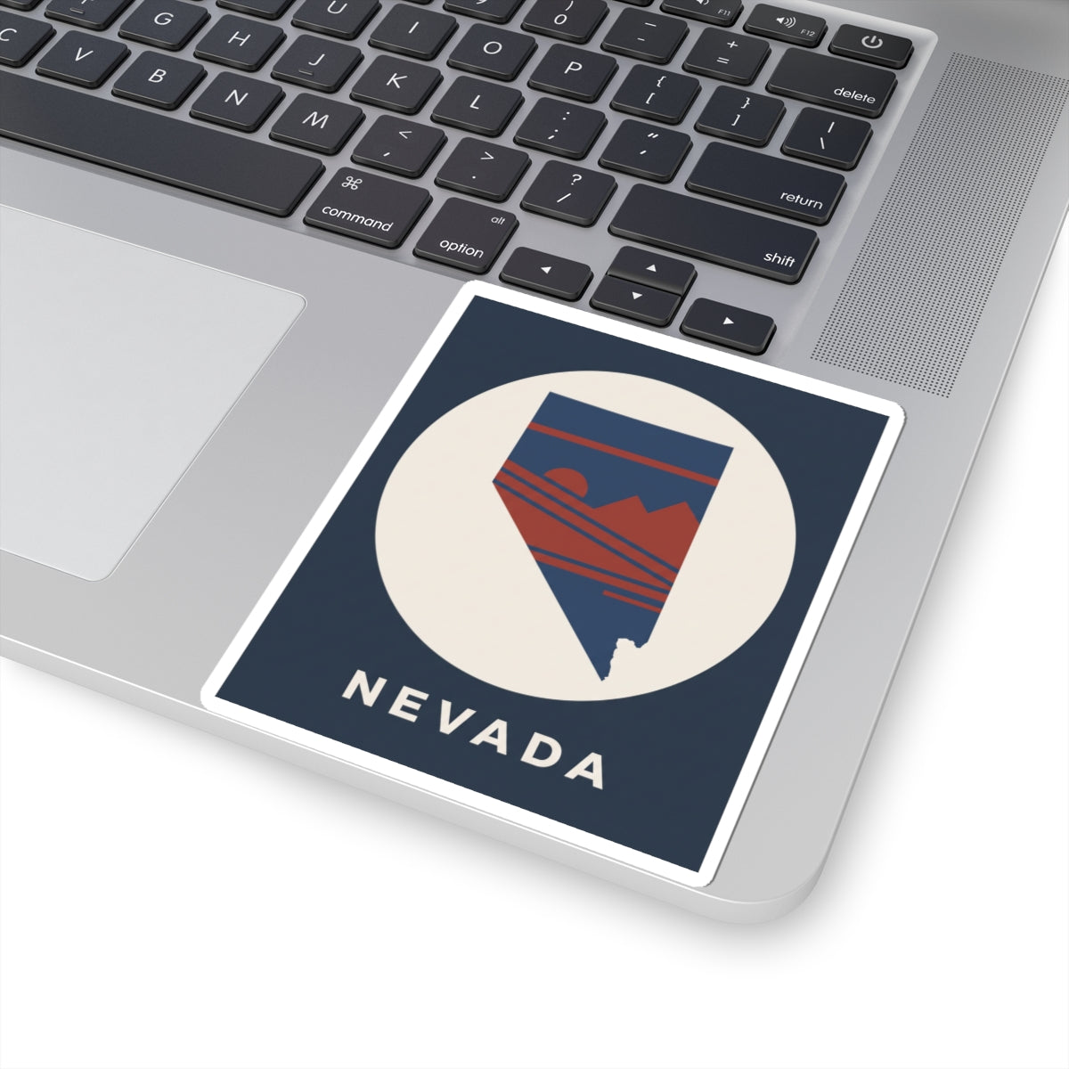 Nevada state kiss-cut sticker on laptop lid, square white border with Nevada silhouette