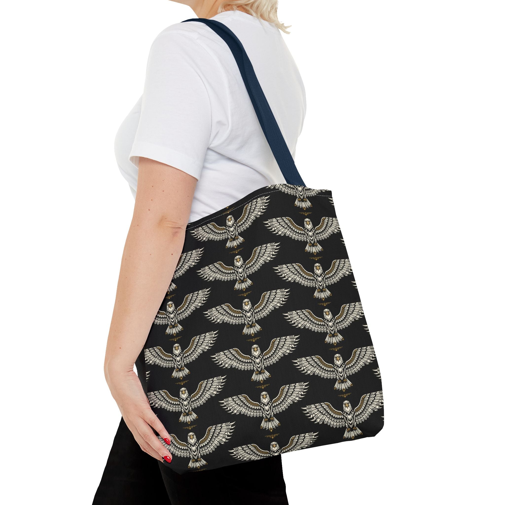 Black tote bag with winged scarab pattern in pale gold and navy shoulder strap