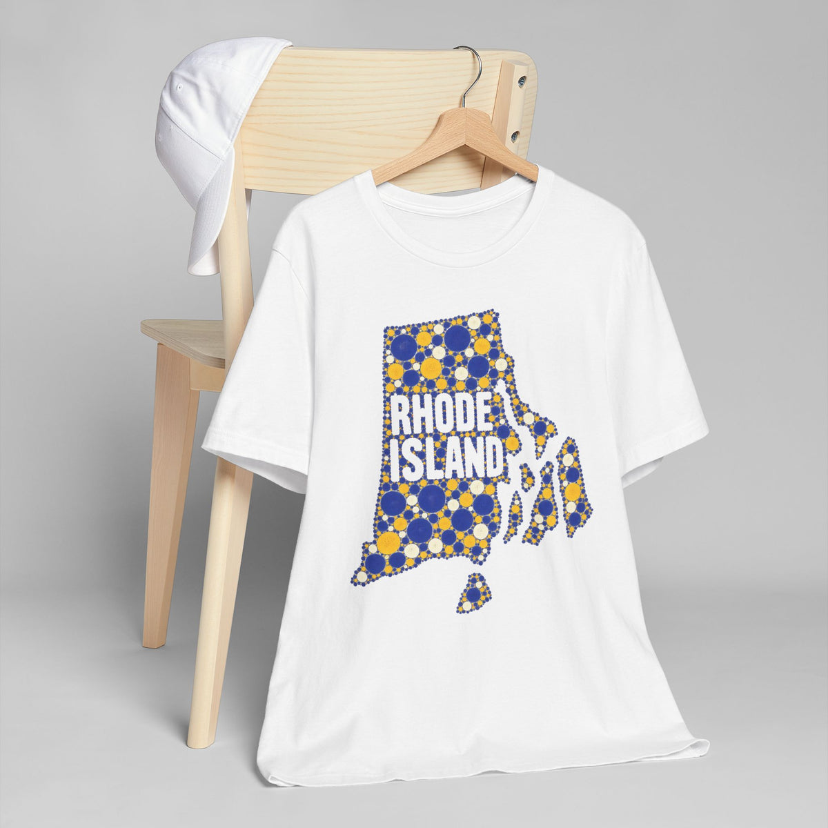 White t-shirt with multicolor polka dot Rhode Island outline graphic on front