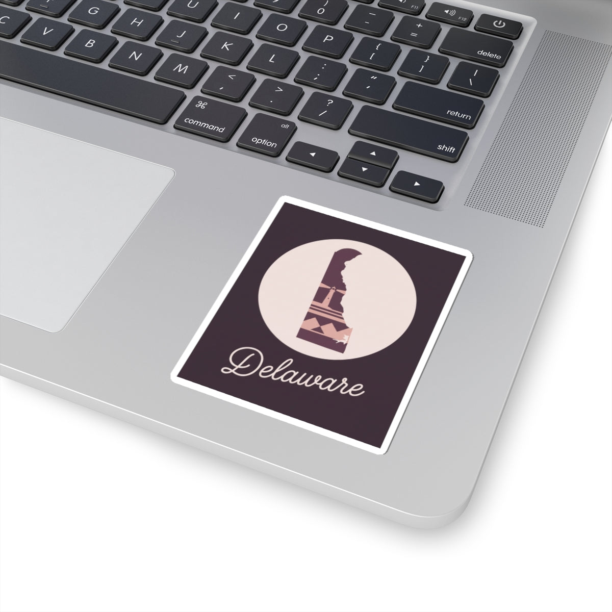 Delaware silhouette vinyl sticker on laptop keyboard, mauve lighthouse and 'Delaware' script