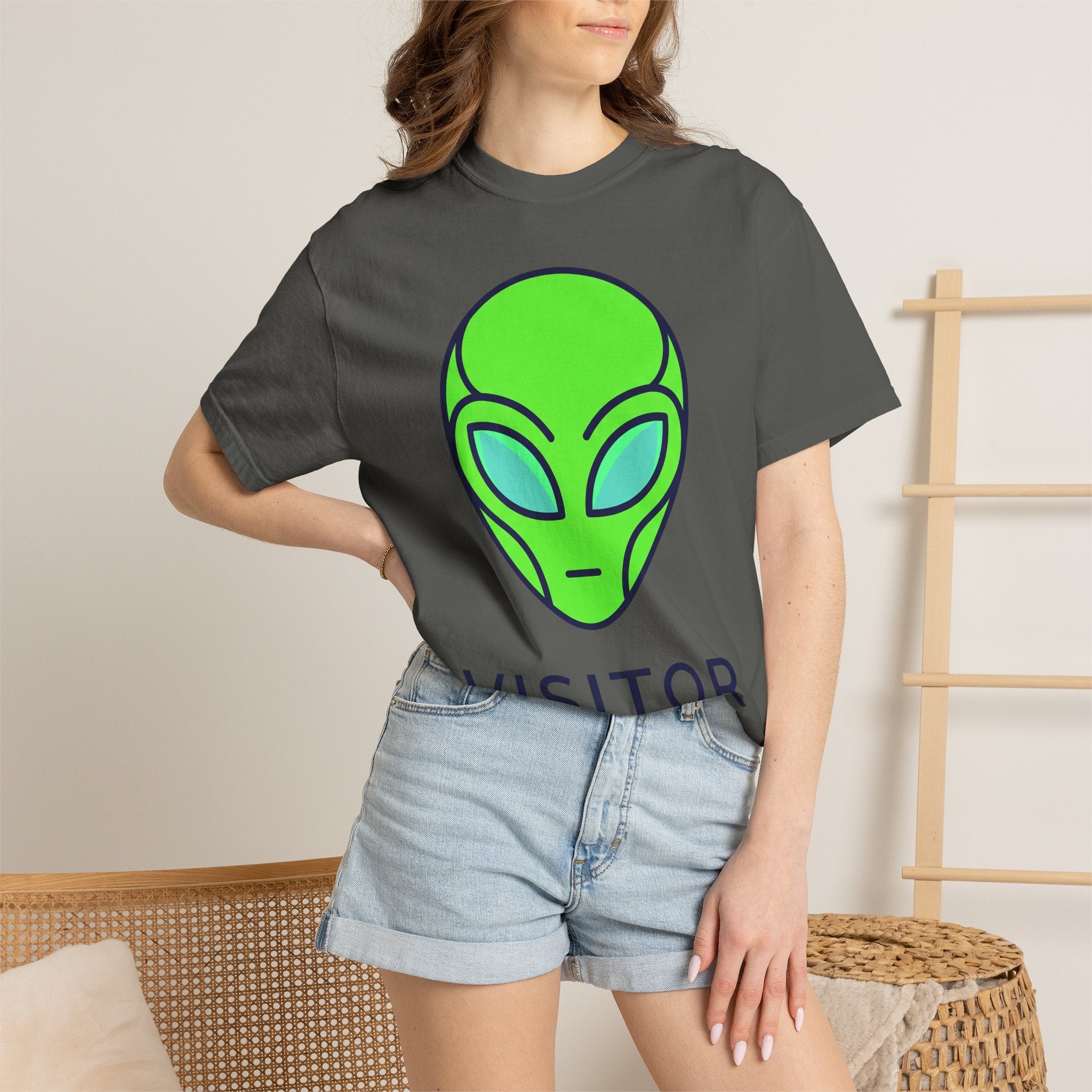 Alien face graphic T-shirt in dark gray with neon green and blue print, worn