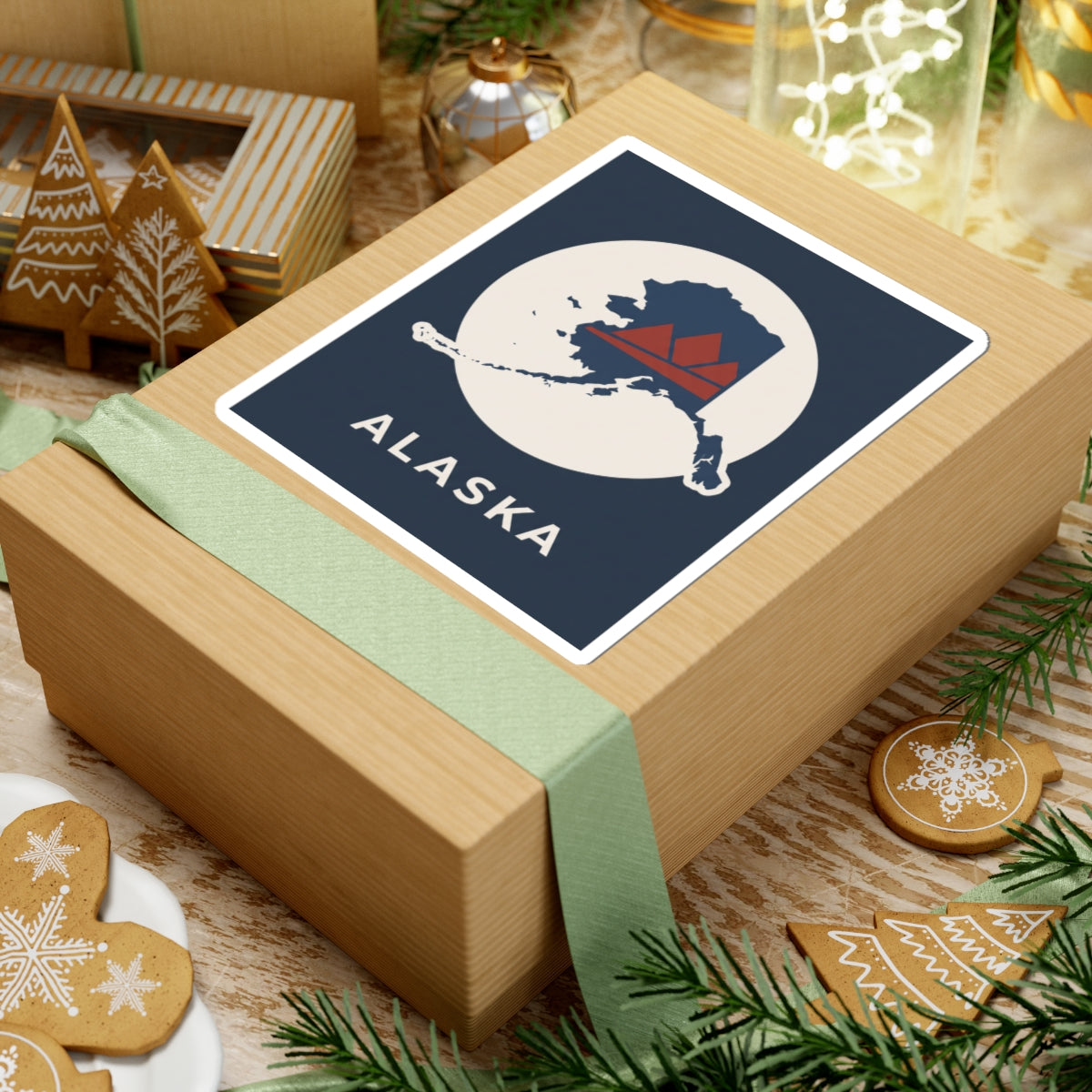 Square Alaska map badge sticker on a wrapped gift, retro mountain in red and navy