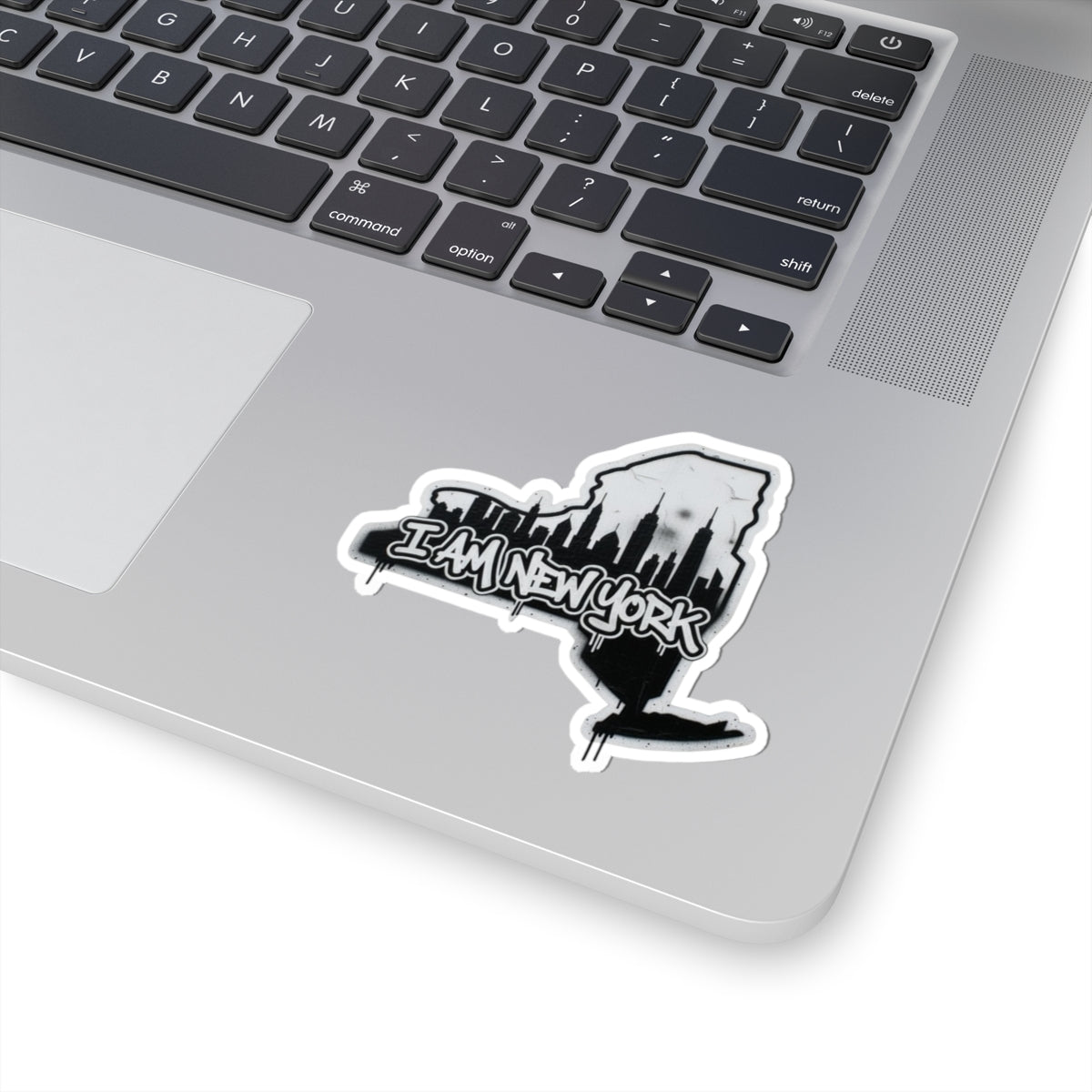 I AM NEW YORK sticker on laptop, white border, black buildings and text