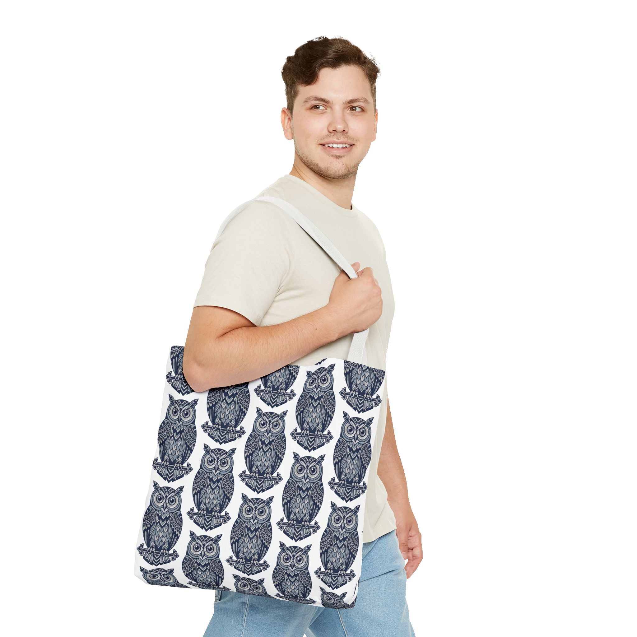 Tote bag with repeating navy owl pattern and white handles, held on shoulder