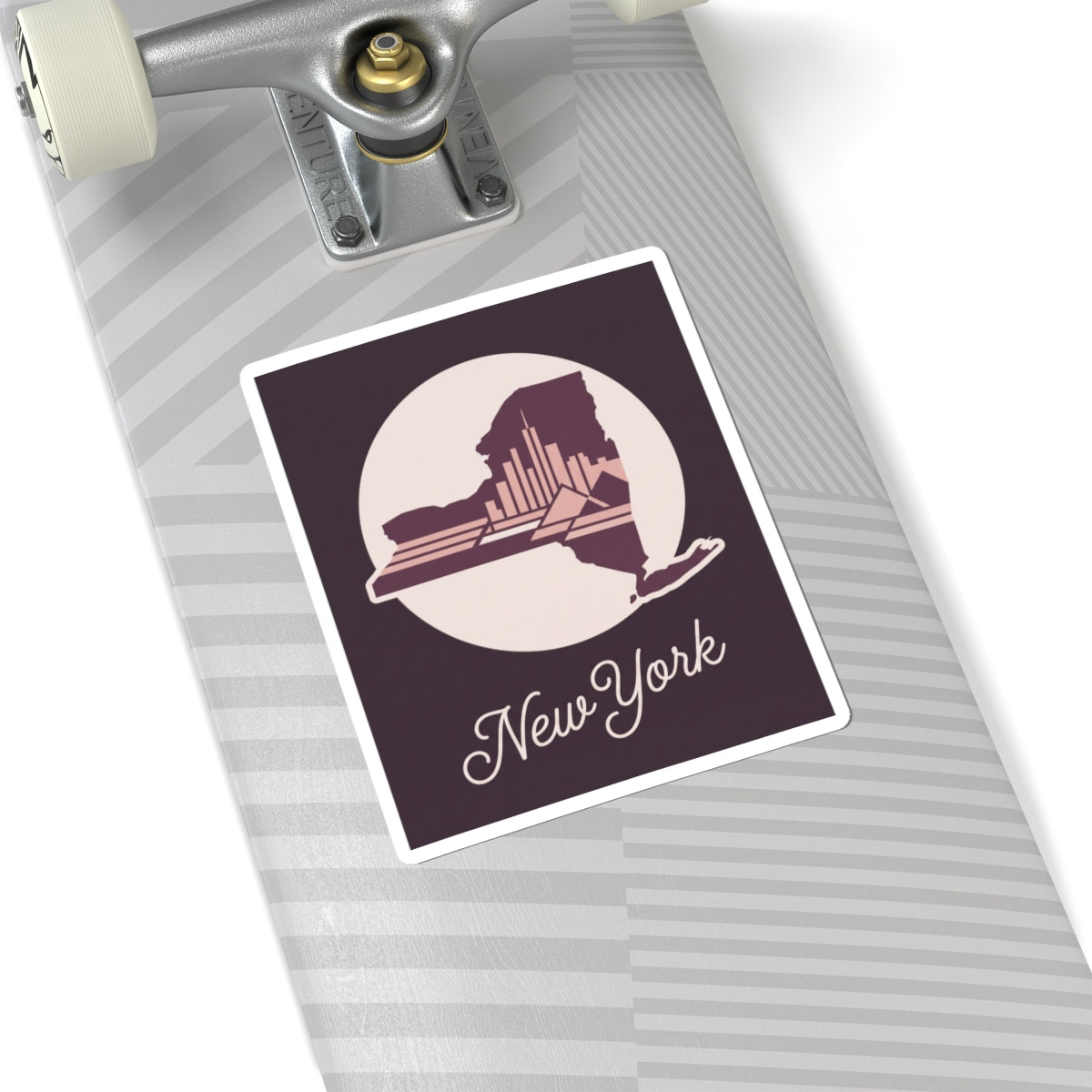 New York skyline decal sticker on a striped suitcase surface, with circular state silhouette and cursive “New York”.