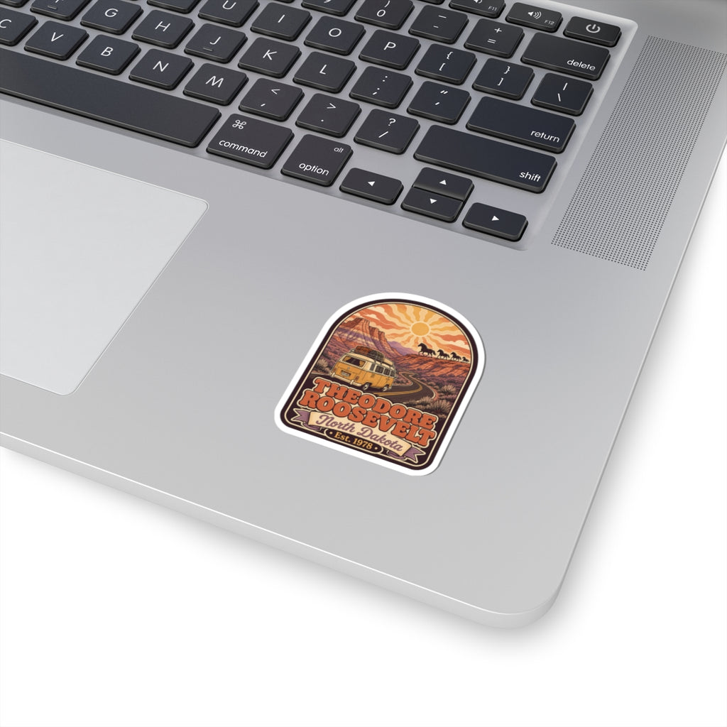 Rounded kiss-cut sticker with retro landscape scene and sun, orange border.