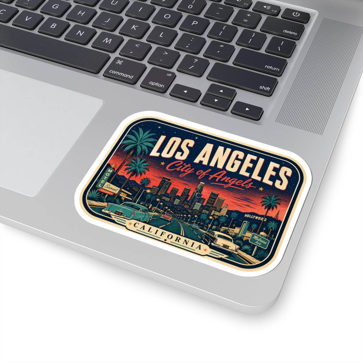 Luggage tag sticker on laptop with Los Angeles lettering and “City of Angels” artwork
