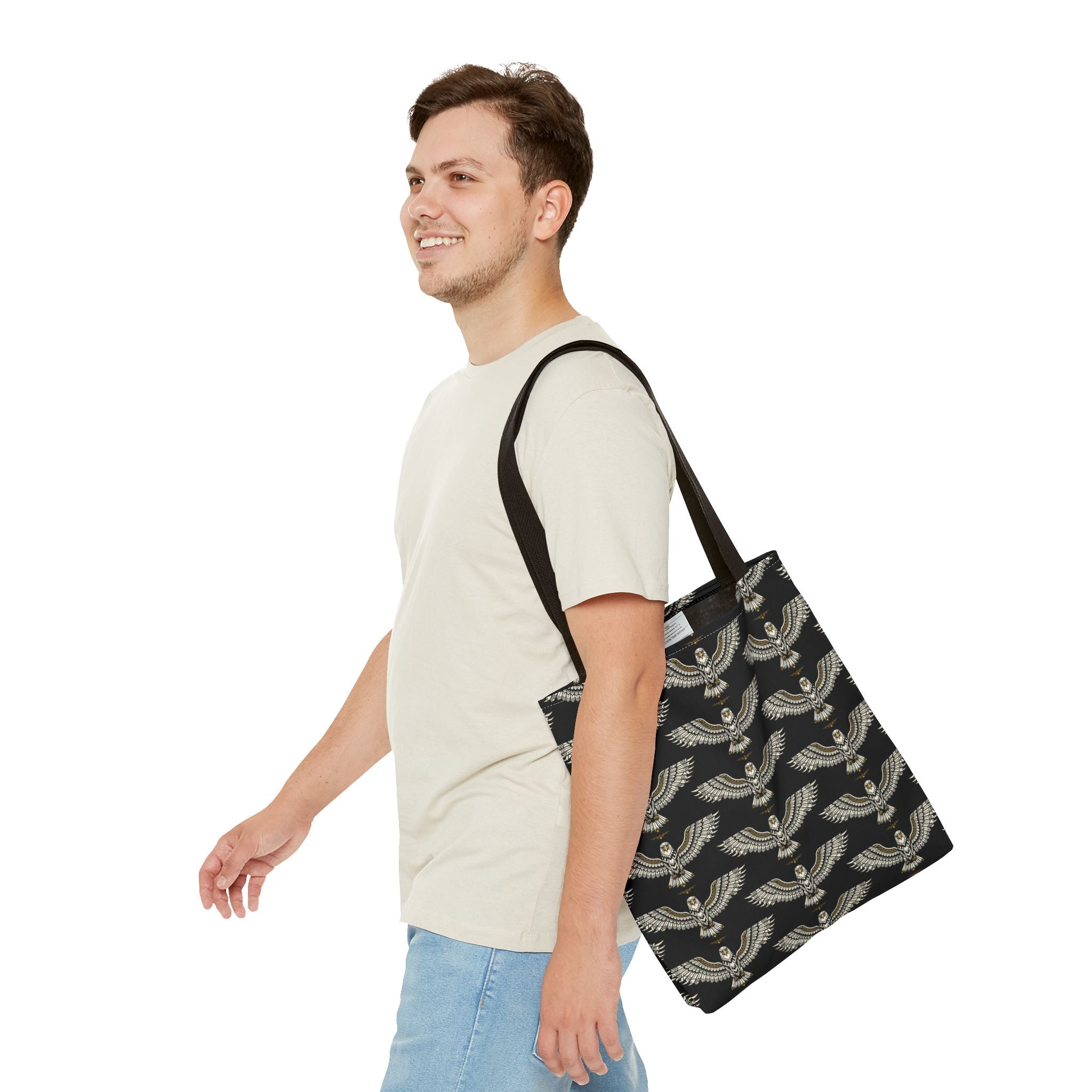 Black tote bag with gold winged scarab pattern, shown worn over shoulder