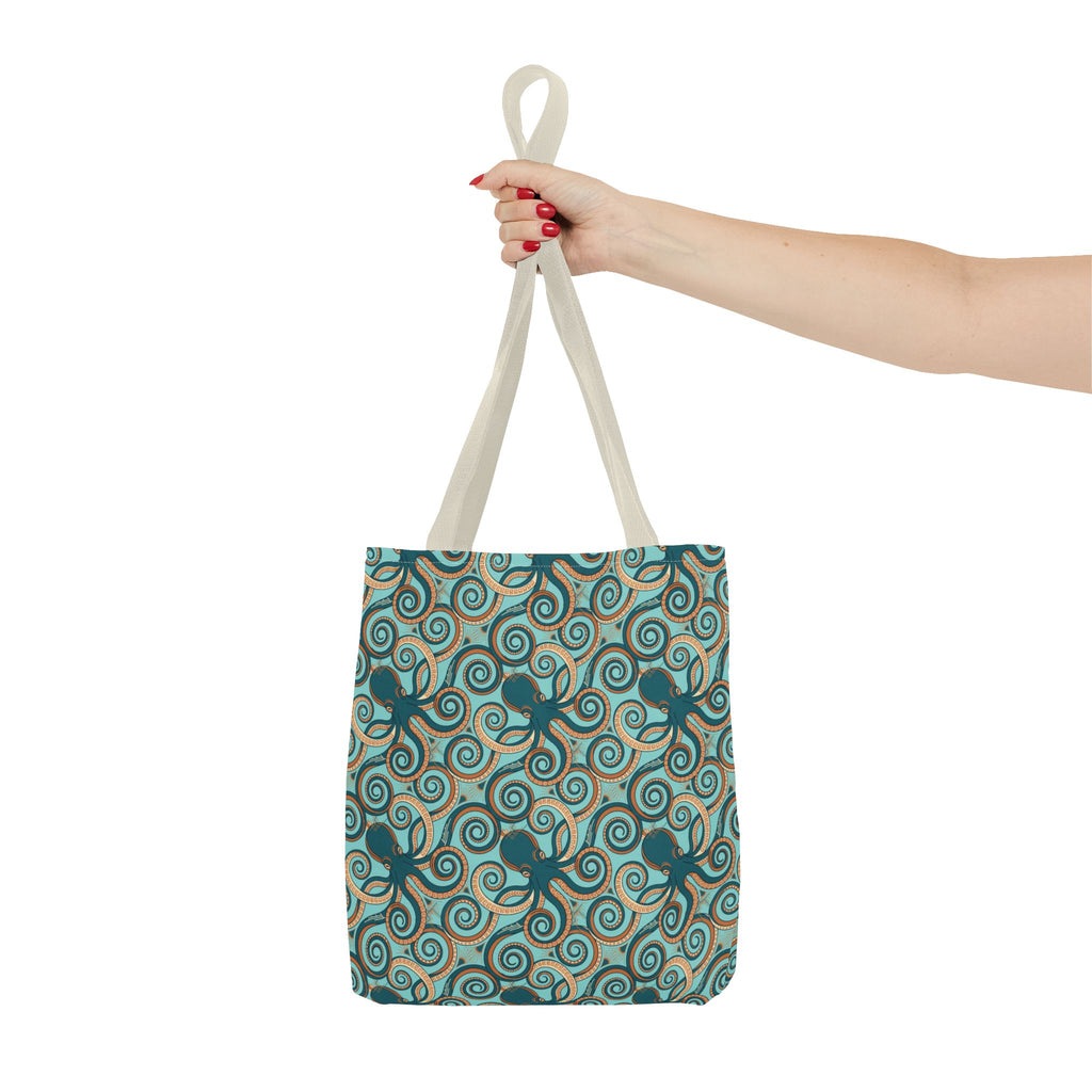Teal octopus swirl tote bag held up by rope handles, all-over print.