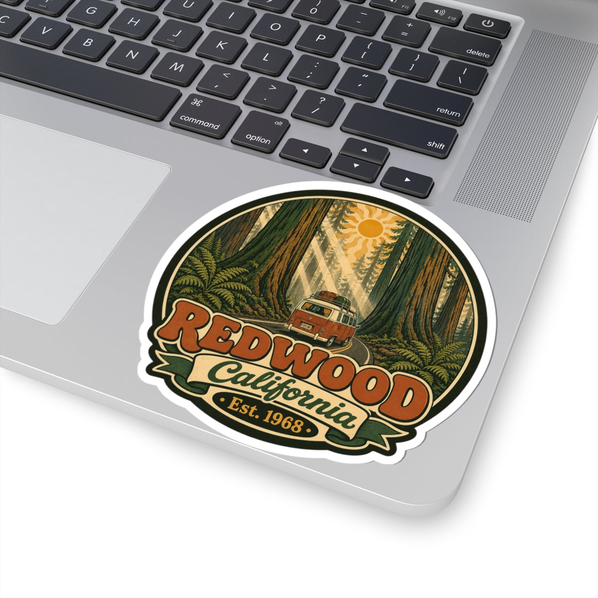 Round kiss-cut sticker featuring redwood trees, sun, camper van, and “Redwood California” text.