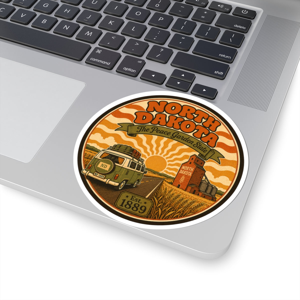 Round North Dakota travel sticker with wheat field scene, truck, and Est. 1889