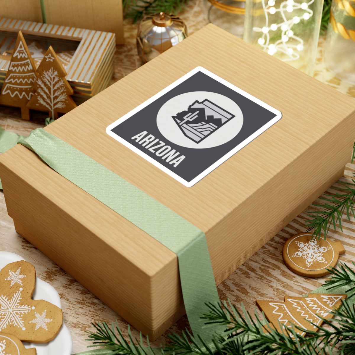 Arizona badge sticker on gift wrap: dark square with white circle desert graphic and ARIZONA