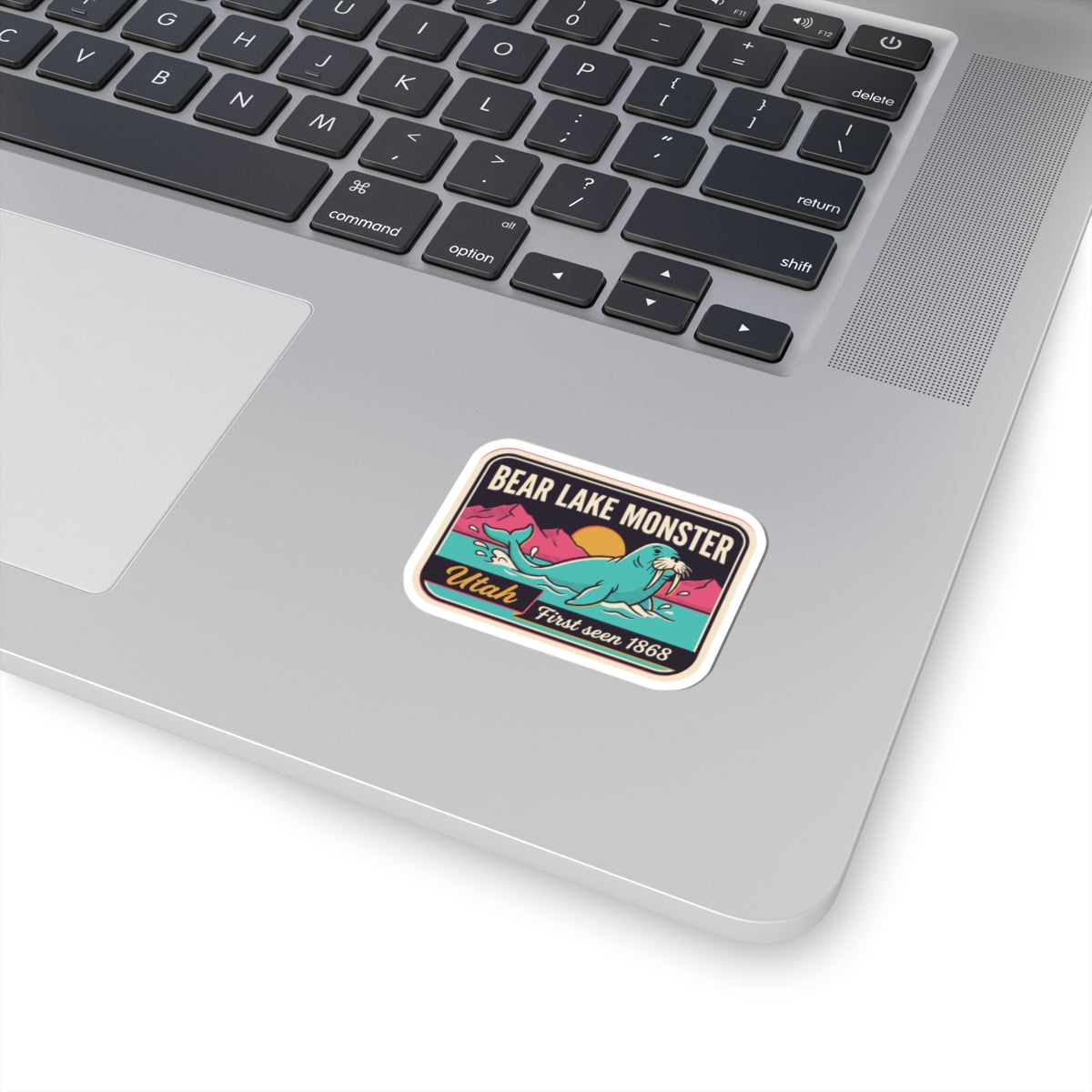Vintage lake monster sticker with teal creature and yellow text, white border
