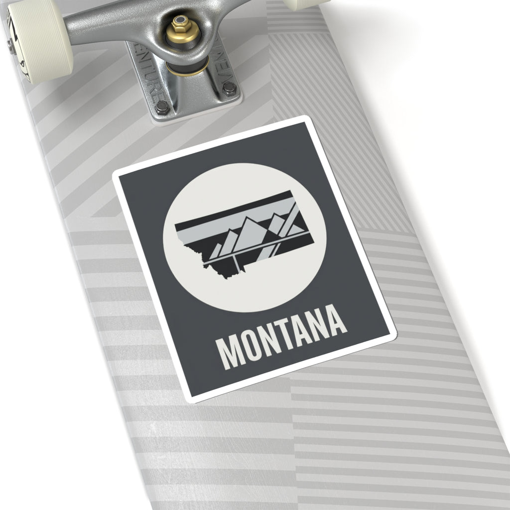 Montana mountain badge sticker on skateboard deck, white circle emblem with landscape graphic and MONTANA
