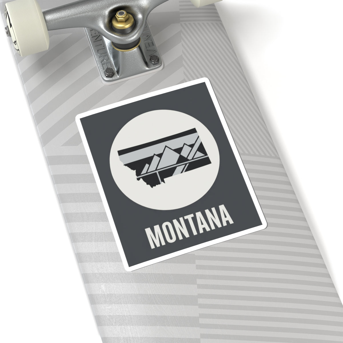 Montana mountain badge sticker on skateboard deck, white circle emblem with landscape graphic and MONTANA