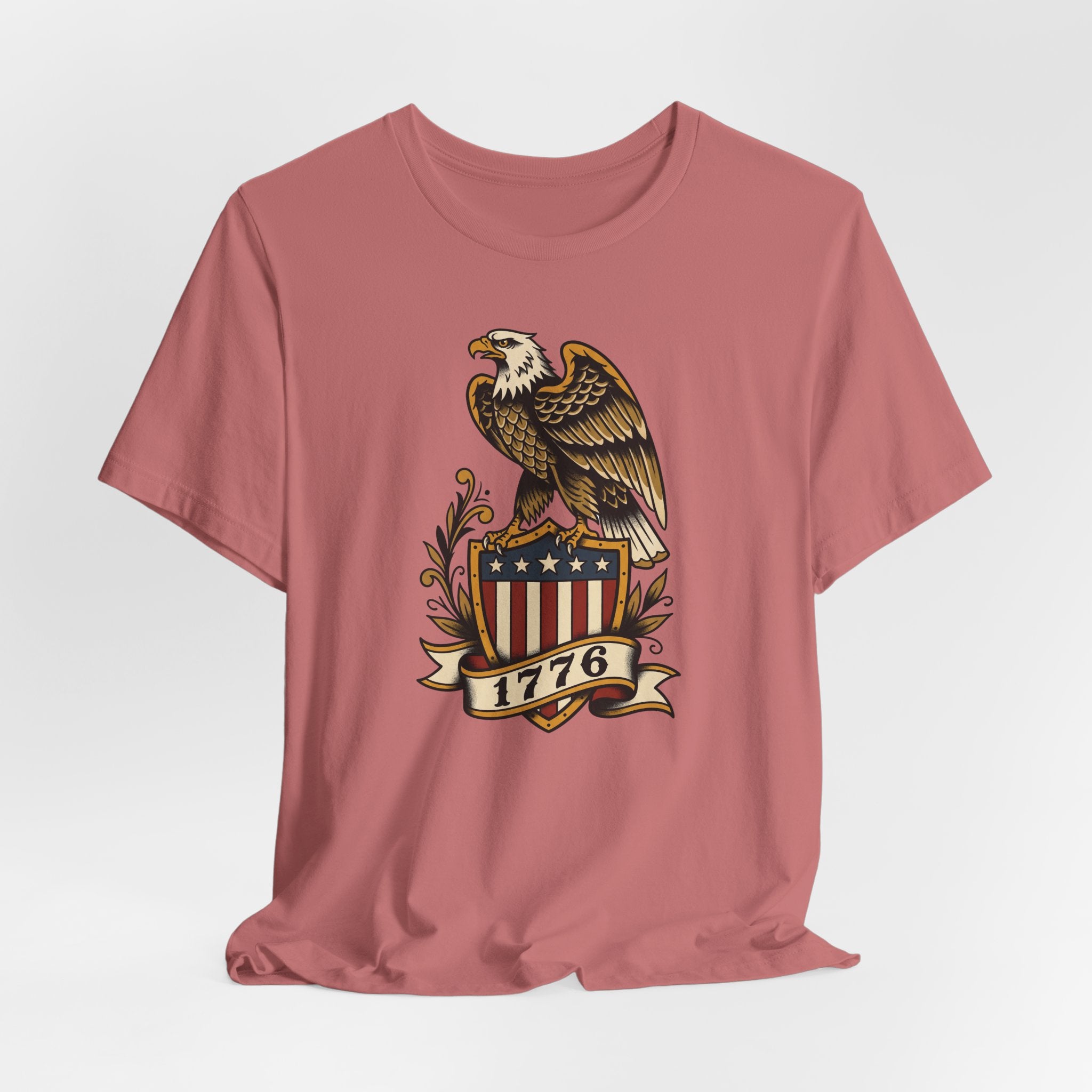Dusty rose crew-neck T-shirt featuring bald eagle shield graphic centered on chest.
