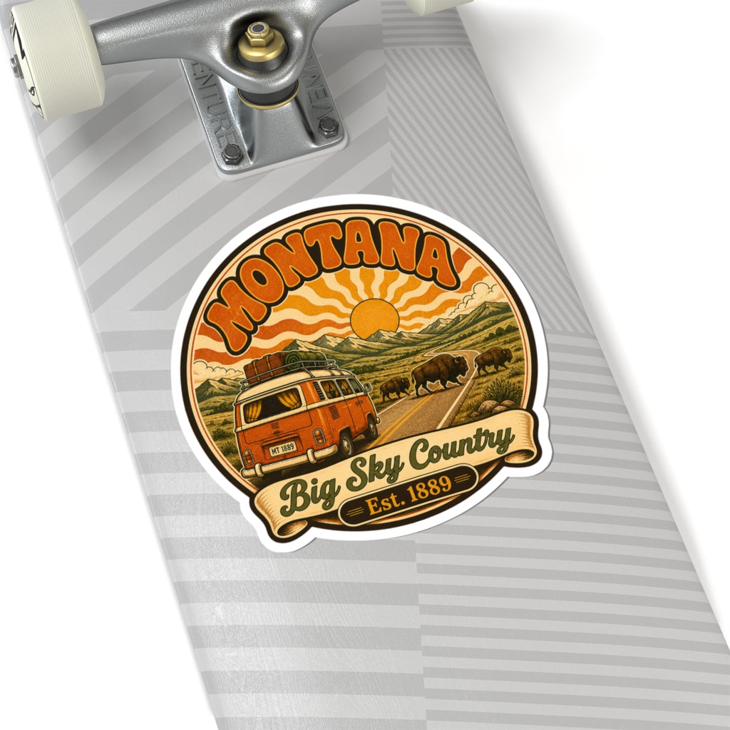 Round white-edged sticker depicting orange camper, buffalo, orange sun, and 'Big Sky Country'