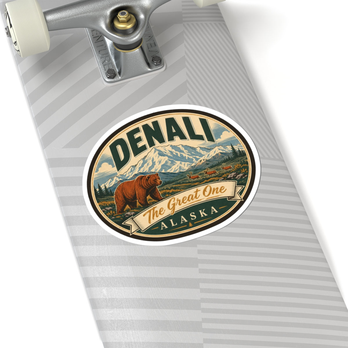 Denali oval sticker on a gray striped surface, bear, mountains, and “The Great One Alaska”
