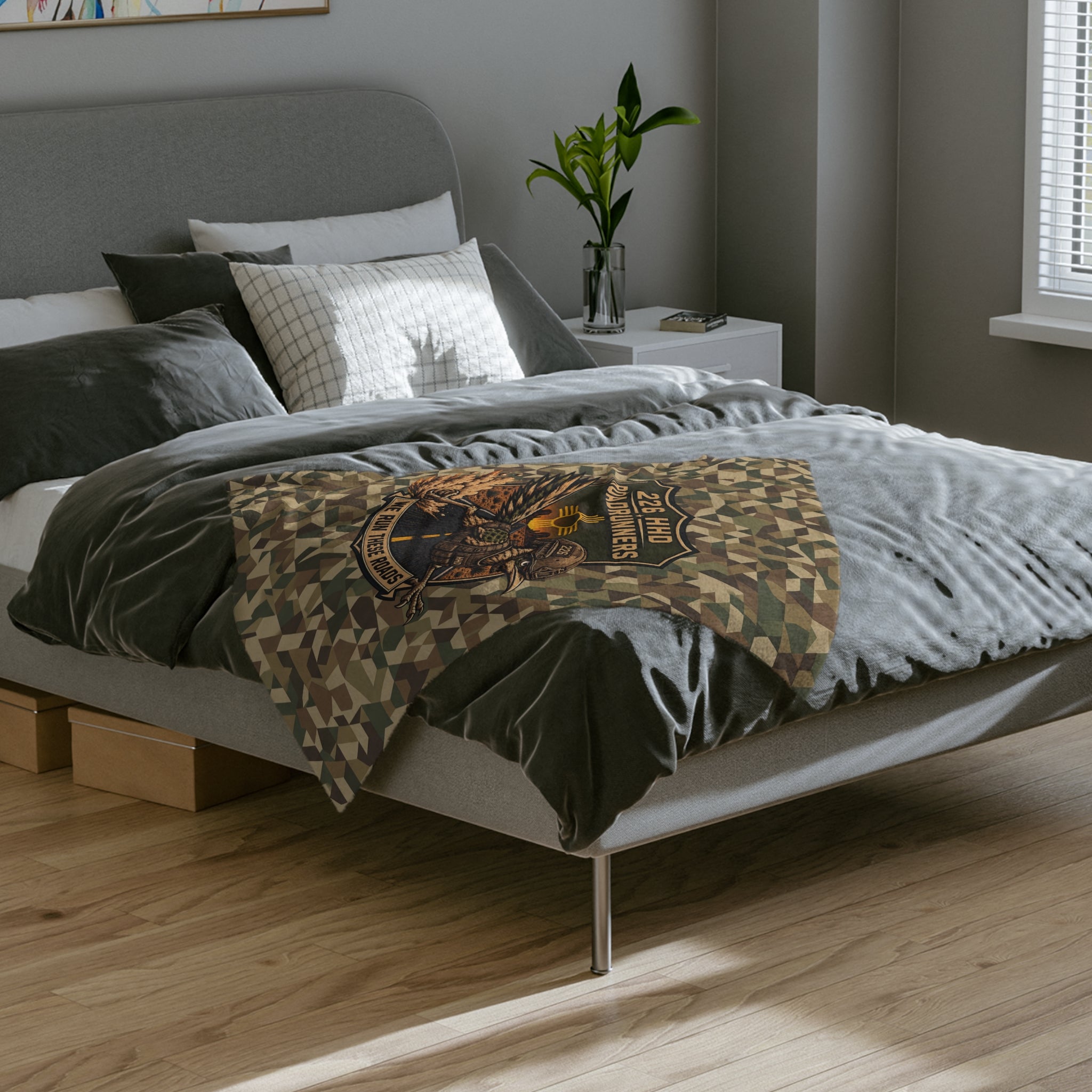Camo microfiber blanket on bed with eagle patch and “We Run These Roads” banner