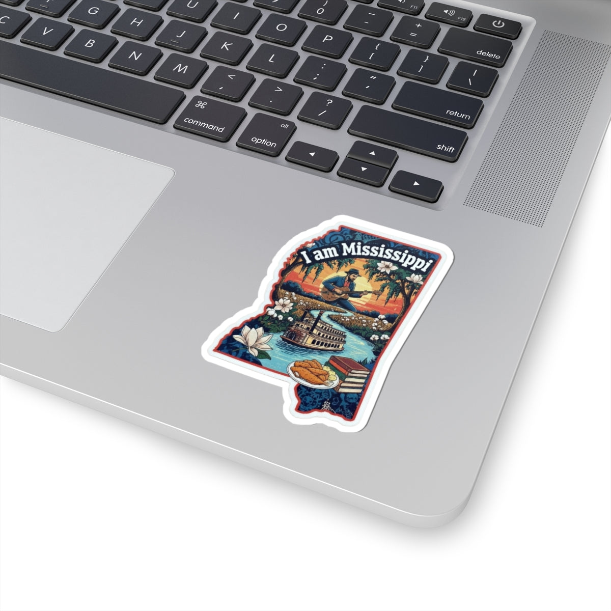 I Am Mississippi sticker on laptop, illustrated Mississippi landscape scene with text.