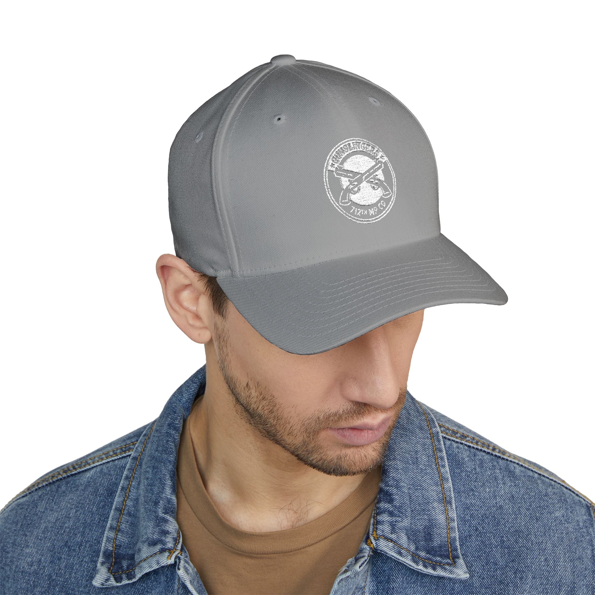 Embroidered baseball cap in light grey with white circular emblem on front panel.