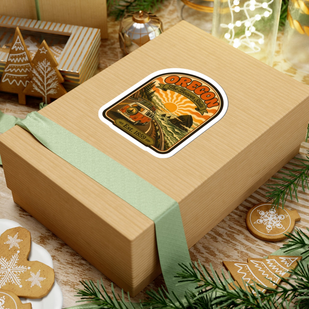 Oregon travel sticker on a gift box ribbon, featuring retro van and coastline art