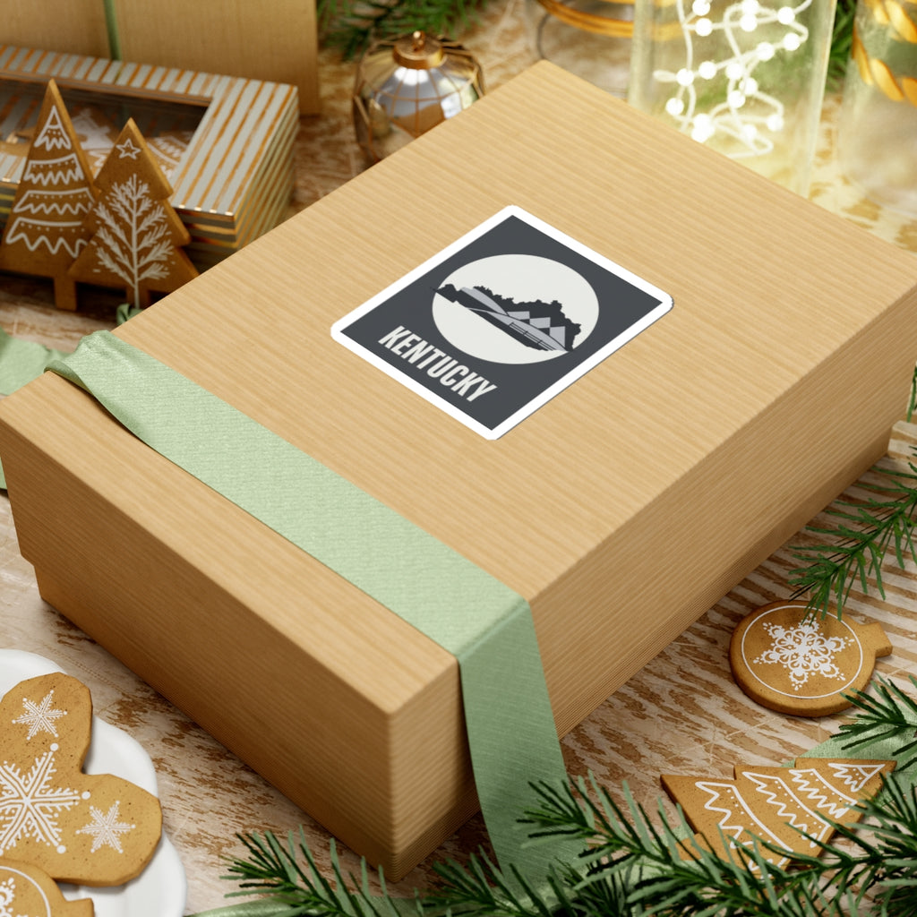 Kentucky vinyl sticker on wrapped gift, dark gray square with white circle and KENTUCKY