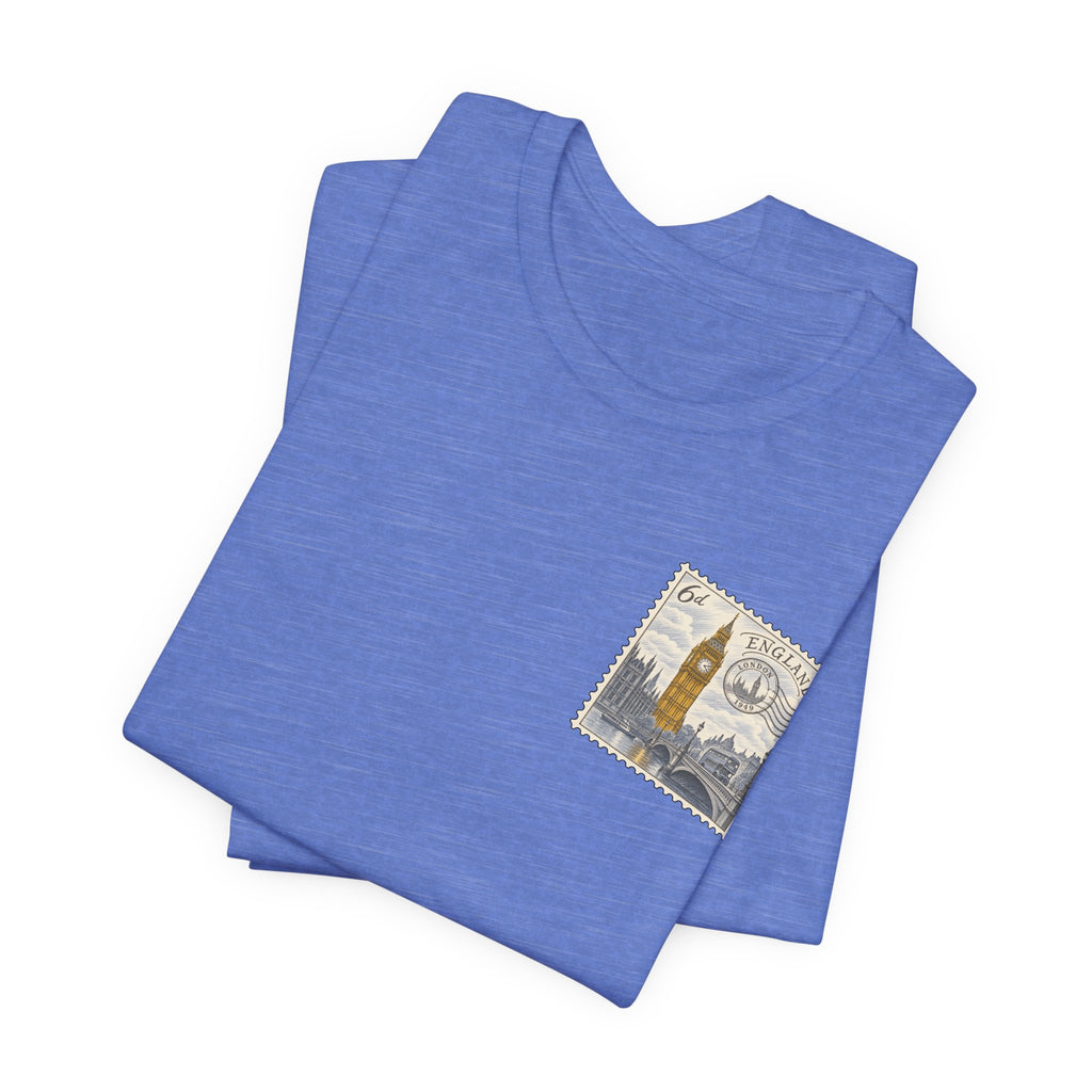 Light blue folded T-shirts with small vintage postage stamp graphic on one front
