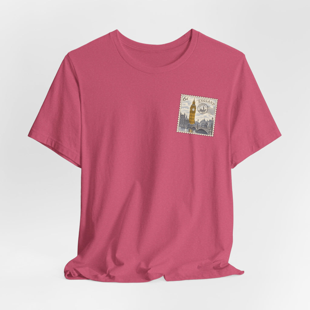 Pink T-shirt with short sleeves and a small vintage postage stamp graphic on the chest