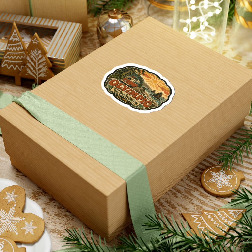 Die-cut sticker showing coastal waves and pine forest with vintage camper, “Olympic Washington”, Est. 1938