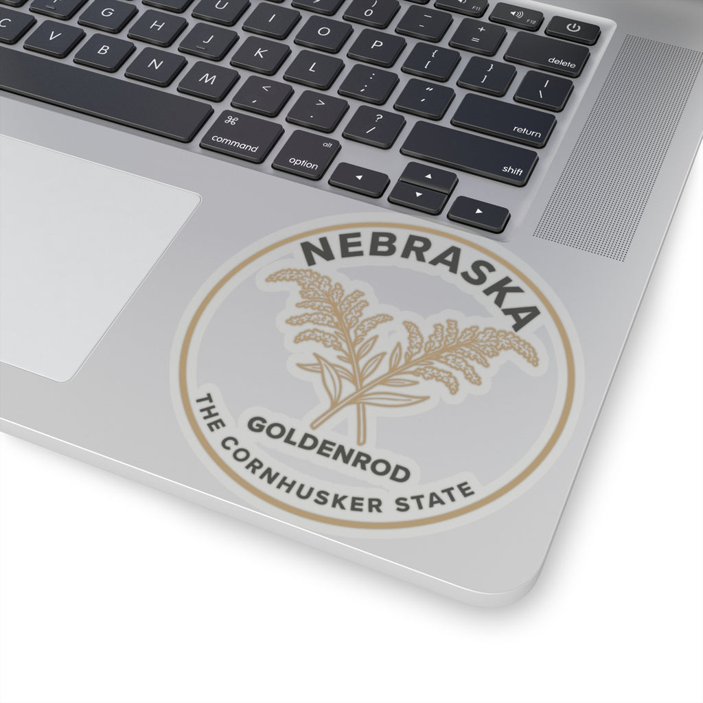 Circular transparent vinyl sticker on laptop lid with Nebraska goldenrod emblem