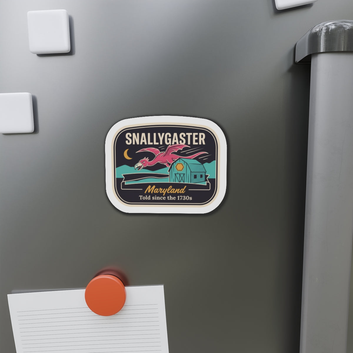 Snallygaster die-cut magnet attached to refrigerator, rounded square with white border and banner.