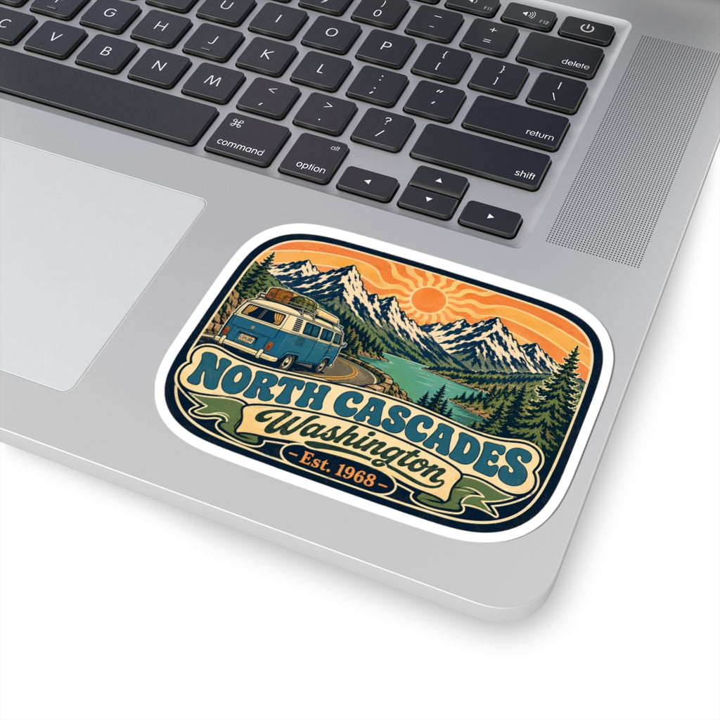 North Cascades sticker on a laptop trackpad area, showing mountains and camper van