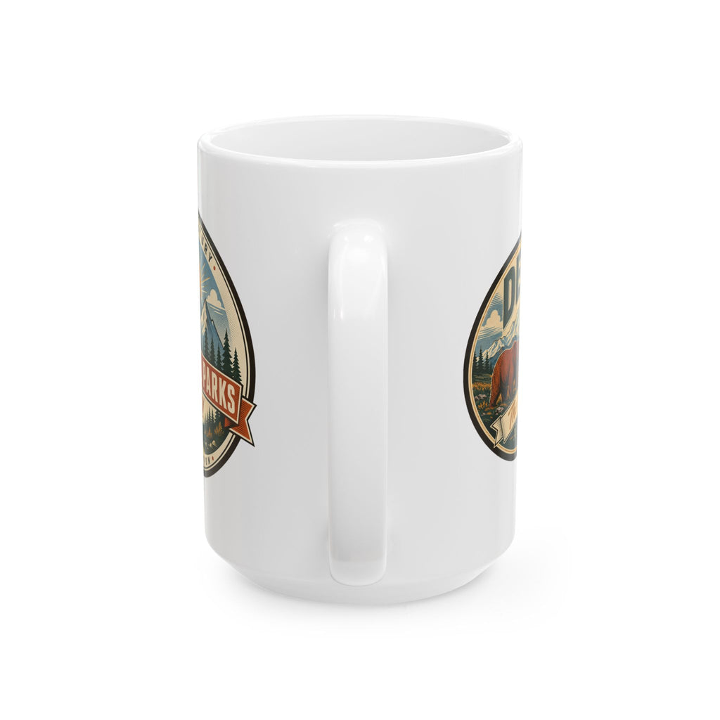 White ceramic mug with two side badge graphics, handle not visible