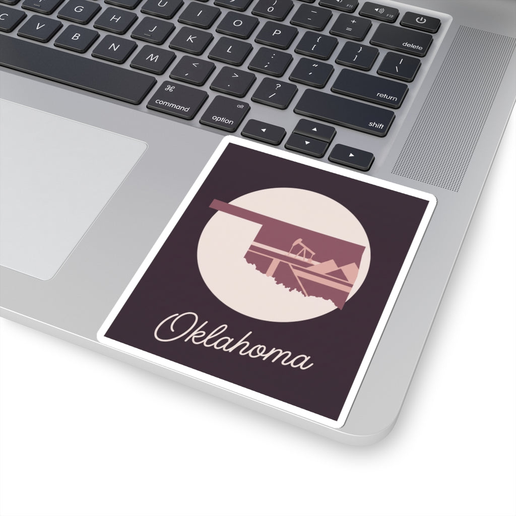 Oklahoma state sticker on laptop: maroon square with oil derrick silhouette and cursive Oklahoma