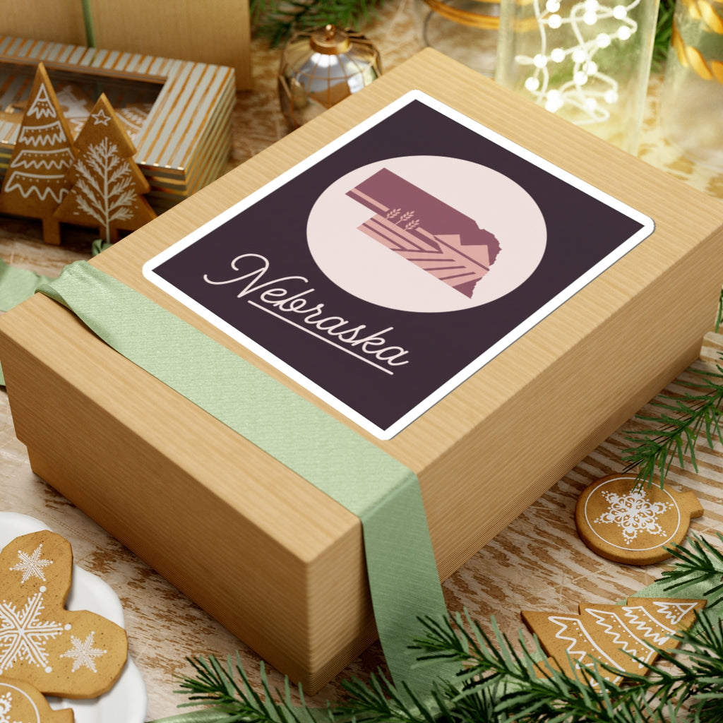 Nebraska square sticker on a gift box top, circular farmland graphic with cursive Nebraska